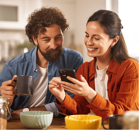 A couple looking at a phone smiling.