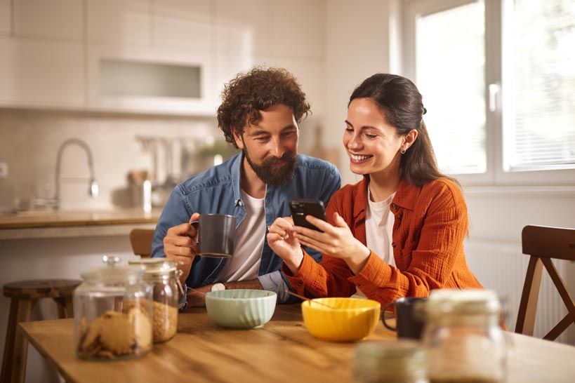 A couple looking at a phone smiling.