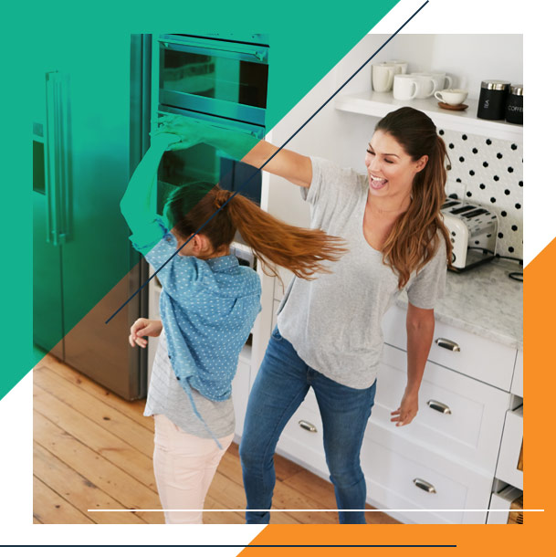 Mother twirling daughter in their kitchen